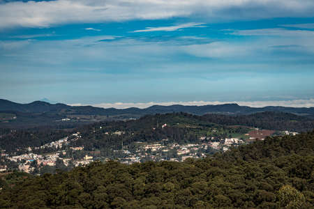 city view with mountain range and bright blue sky from hill top at day image is taken from doddabetta peak ooty india. it is showing the bird eye view of ooty city with mountain range in background.の写真素材