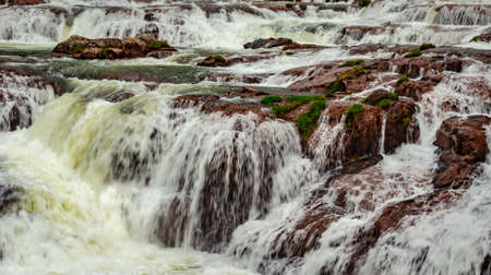 waterfall with red rock and green lush forest flat angle shot image is taken at pykara lake ooty tamilnadu south india. it is showing the beautiful landscape of south india.の写真素材