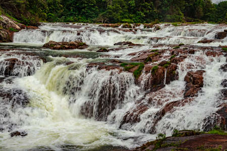waterfall with red rock and green lush forest flat angle shot image is taken at pykara lake ooty tamilnadu south india. it is showing the beautiful landscape of south india.の写真素材