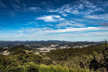 city view with mountain range and bright blue sky from hill top at day image is taken from doddabetta peak ooty india. it is showing the bird eye view of ooty city with mountain range in background.の写真素材