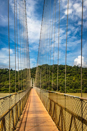 suspension iron cable bridge isolated with bright blue sky from unique different angle image is taken at honnavar karnataka india. it is the fine example of modern engineering.の写真素材