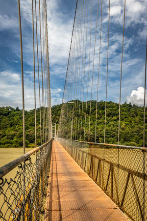 suspension iron cable bridge isolated with bright blue sky from unique different angle image is taken at honnavar karnataka india. it is the fine example of modern engineering.の写真素材