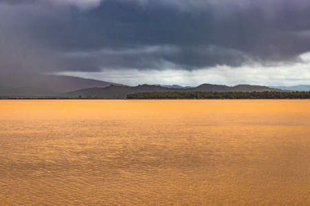 pristine landscape with lake calm water and dramatic sky at morning from flat angle image is taken at om beach gokarna karnataka india.の写真素材