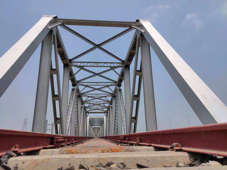 railway tracks iron bridge unique angle shot with flat skyの写真素材