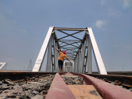 man at railway tracks iron bridge unique angle shotの写真素材