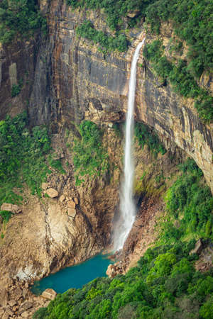 waterfall streams falling from mountain top covered with green forests at day image is taken at Nohkalikai Falls cherrapunji meghalaya india. it is the tallest plunge waterfall in Indiaの写真素材