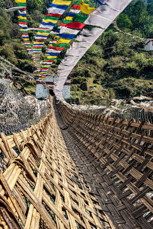 ancient holy bamboo bridge with many buddhist holy flags from unique perspective image is taken at chaksam bridge tawang arunachal pradesh india.の写真素材