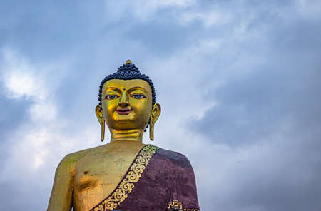 isolated huge buddha golden statue from different perspective with moody sky at evening image is taken at giant buddha statue tawang arunachal pradesh india.の写真素材