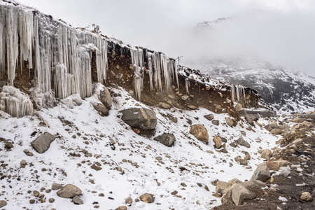 frozen icicles sticking at mountain peak at winter in morningの写真素材
