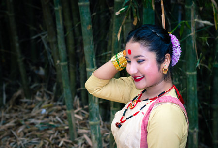 girl smiling face isolated dressed in traditional wearing on festival with blurred background image is taken on the occasion of bihu at assam india.の写真素材