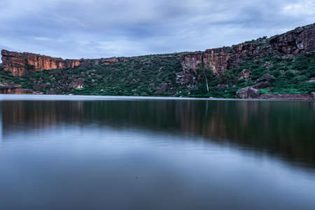 lake pristine with mountain background and bright sky long exposure shot at dusk image is showing the beauty of Bhutanatha Temple on the shores of Agastya Tirtha at Badami karnataka india.の写真素材