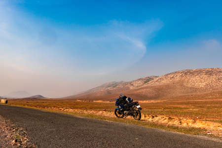 countryside empty rural road with motorcycle parked and surrounded by mountains at morning image is taken at dashrath manjhi path gaya bihar India on Feb 11 2020. It is the serene beauty of bihar.の写真素材
