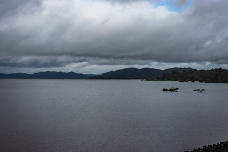 river serene back water with mountain shadow and dramatic cloudy sky image is taken at Supa Dam dandeli karnataka india. The backwaters is totally stunning.の写真素材