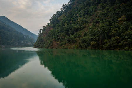 river flowing calm in blue color with mountain reflection image is the tista river of sikkim india, It is showing the beautiful flow of river with amazing reflection.の写真素材