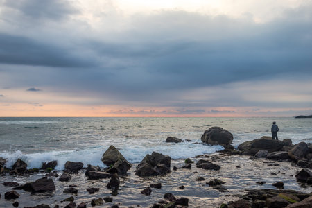 Man standing Isolated watching the sea horizon. It has the space for text writing with amazing background.の写真素材