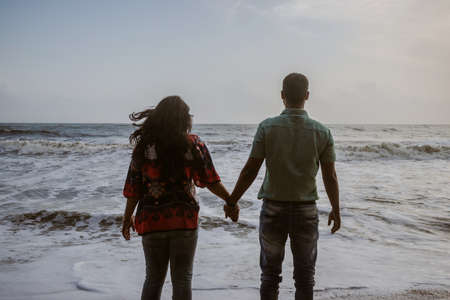 Couple holding each others hand and soaking up the natural sea view image is taken at kochi kerala india showing the love of couple in the true nature.の写真素材