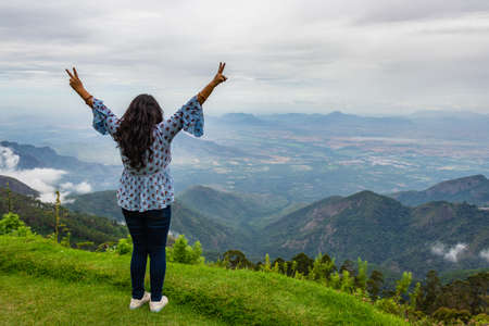 Girl Isolated soaking natural beauty from hill top image is showing the human love towards the nature. Image taken at Kodaikanal tamilnadu India from top of the hill.の写真素材