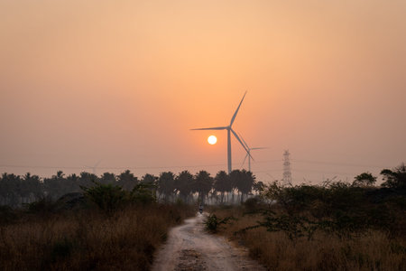 Sunrise with windmills and country roads is the real example of developing rural life. Image is...