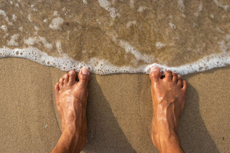 human feet feeling nature isolated on sandy beach showing the human love of nature. The true expression of human life.の写真素材