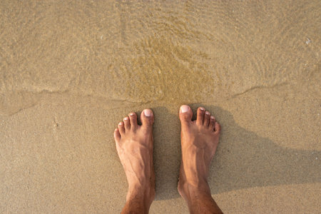 human feet feeling nature isolated on sandy beach showing the human love of nature. The true...
