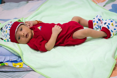 cute newborn baby looking at camera in red dress from different angle