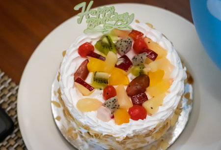 birthday isolated fruit cake decorated with strawberries at coffee table