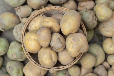 fresh potatoes from farm in bamboo bowl from top angle at dayの写真素材