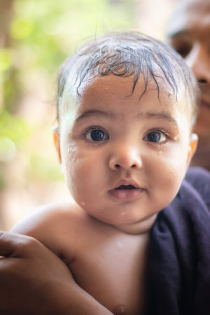 cute infant facial expressing after bathing from flat angle indoor shotの写真素材