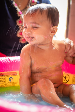 cute infant facial expressing while bathing from flat angle indoor shotの写真素材