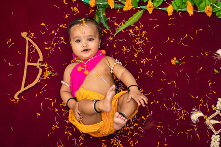 cute Indian boy dresses as lord rama with bow and flowers from top angleの写真素材