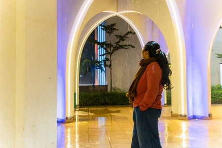 girl watching wall lightnings indoor shot at eveningの写真素材