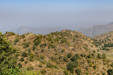 misty mountain range covered with fog at morning from flat angle image is taken at Kumbhal fort kumbhalgarh rajasthan india.の写真素材