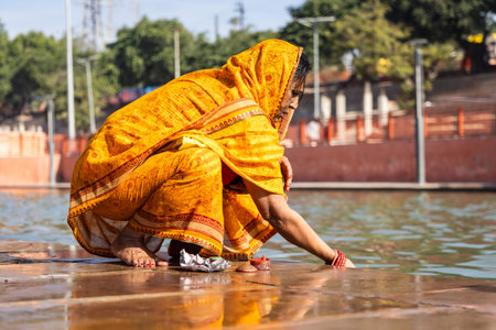 devotee praying for holy god after bathing in holy river water at morning from flat angleの写真素材