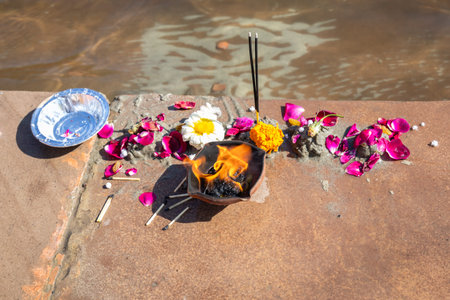 holy offerings by devotee at religious river shore at morning from flat angle