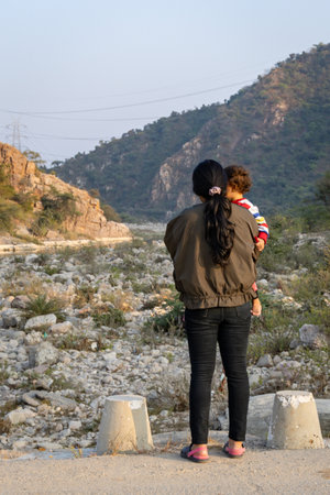 isolated young mother and son enjoying mountain landscape at morning with blurred backgroundの写真素材