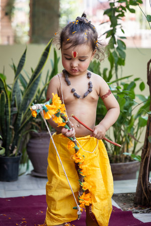 Portrait of cute Indian boy dresses as lord rama with bow at outdoor with blurred background at day