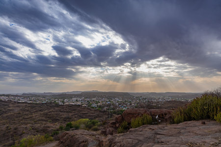 city view with dramatic sun beams orange sky at evening from mountain top image is taken at...
