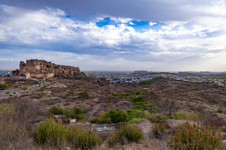 ancient historical fort with blue colored city houses and dramatic cloudy sky at evening image is taken at mehrangarh fort jodhpur rajasthan india.の写真素材