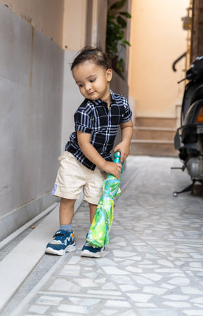 cute infant with umbrella at outdoor from different angleの写真素材