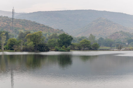 pristine lake surrounded by green mountains at morning from flat angle