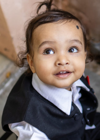 cute indian toddler baby boy in black suit at outdoor from different angleの写真素材