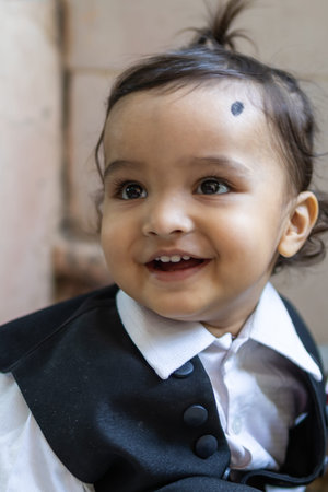 cute indian toddler baby boy in black suit at outdoor from different angle