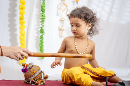 little indian baby boy in holy hindu god kirshna attire at indoorの写真素材
