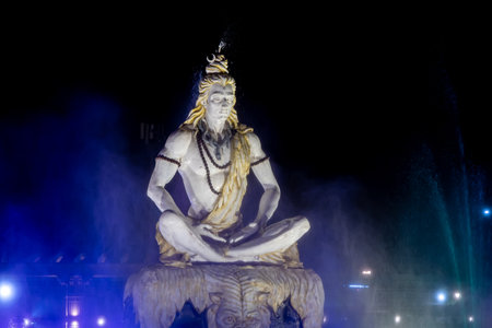dramatic idol of hindu holy god lord shiva sitting in mediation at outdoor at nightの写真素材