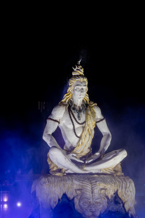 dramatic idol of hindu holy god lord shiva sitting in mediation at outdoor at nightの写真素材
