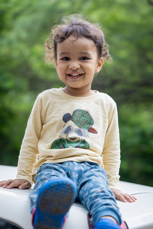 cute indian kid smiling face with blurred background at day
