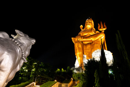 Isolated Statue of holy Hindu Lord Shiva in Meditation Posture with holy bull and dark sky at nightの写真素材