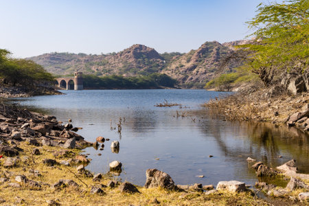pristine lake calm water with mountain background at day from different angle image is taken at kayalana lake jodhpur rajasthan india.の写真素材