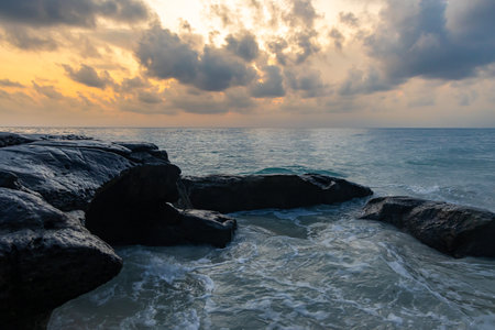 sunrise dramatic sky over sea horizon from rocky shore at dawn from flat angle image is taken at Kala Pathar Beach havelock Andaman and Nicobar Islands.の写真素材