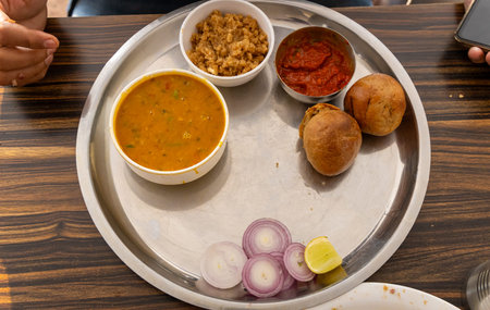 authentic indian traditional food dal bati churma served in steel plate from top angle image is...